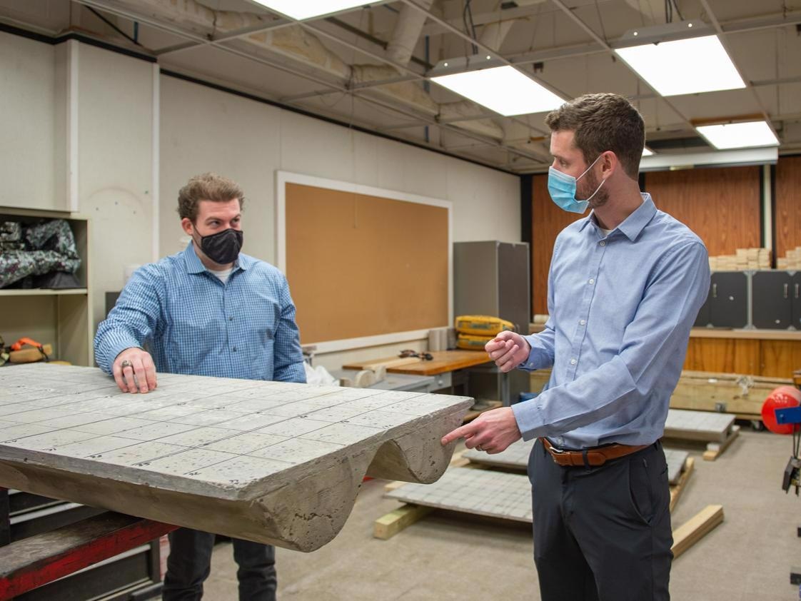 Penn State researchers investigated a method for better balancing sustainability with desirable acoustic properties in concrete floor slabs similar to the one shown in this photo with, left, Jonathan Broyles, an architectural engineering doctoral candidate, and Nathan Brown, assistant professor of architectural engineering. This scaled-down slab, fabricated in collaboration with Jonathan C. Boliek, an independent contractor, is a model for future research with Micah Shepherd, assistant research professor of acoustics and a paper co-author.